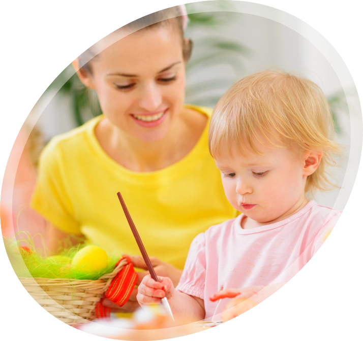 a young girl painting something with her teacher