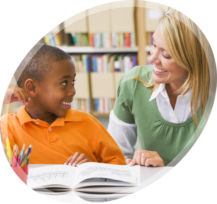 a young boy reading with her teacher